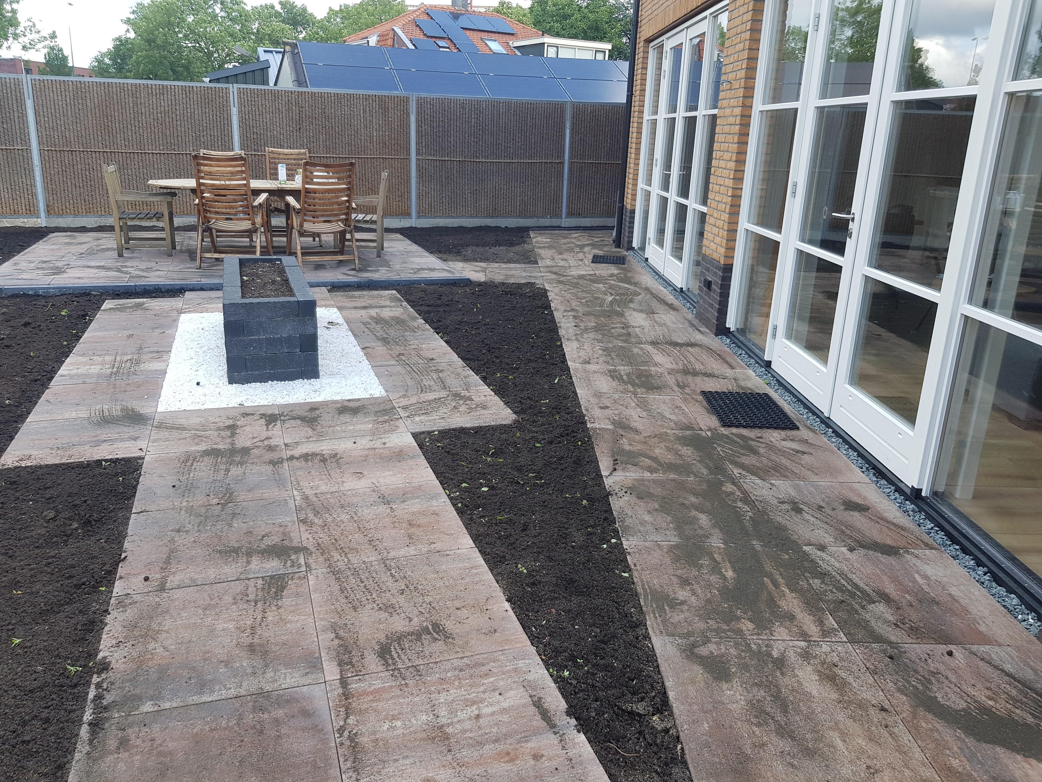 Zithoek achtertuin, grote tegels, plantenbak, grind